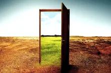 Open wooden door to the new world with green environment. Climate change concept.