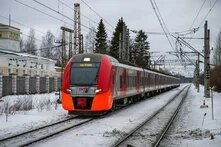 Ein roter und silberner Zug, der über Bahngleise fährt.